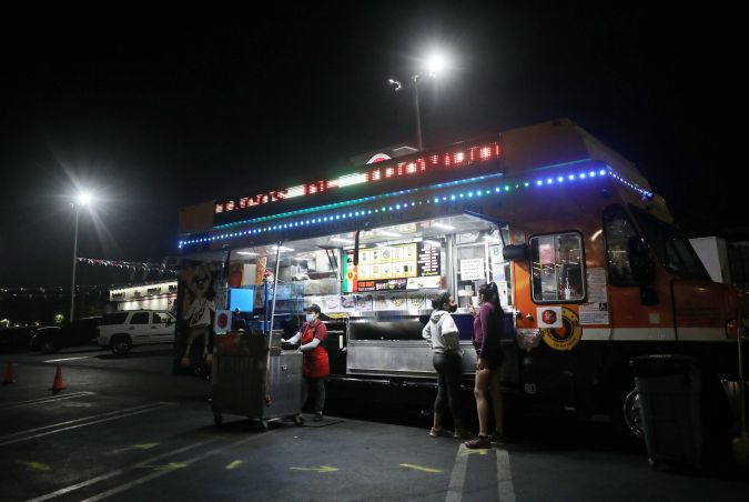 LOS ANGELES, CALIFORNIA - JULY 01: Customers order from a taco truck amid the COVID-19 pandemic on July 1, 2020 in Los Angeles, California. California Governor Gavin Newsom ordered indoor dining restaurants to close again today in Los Angeles County and 18 other counties for at least three weeks amid a surge in new coronavirus cases. Restaurants and food trucks may remain open for takeout and drive-through orders. (Photo by Mario Tama/Getty Images)