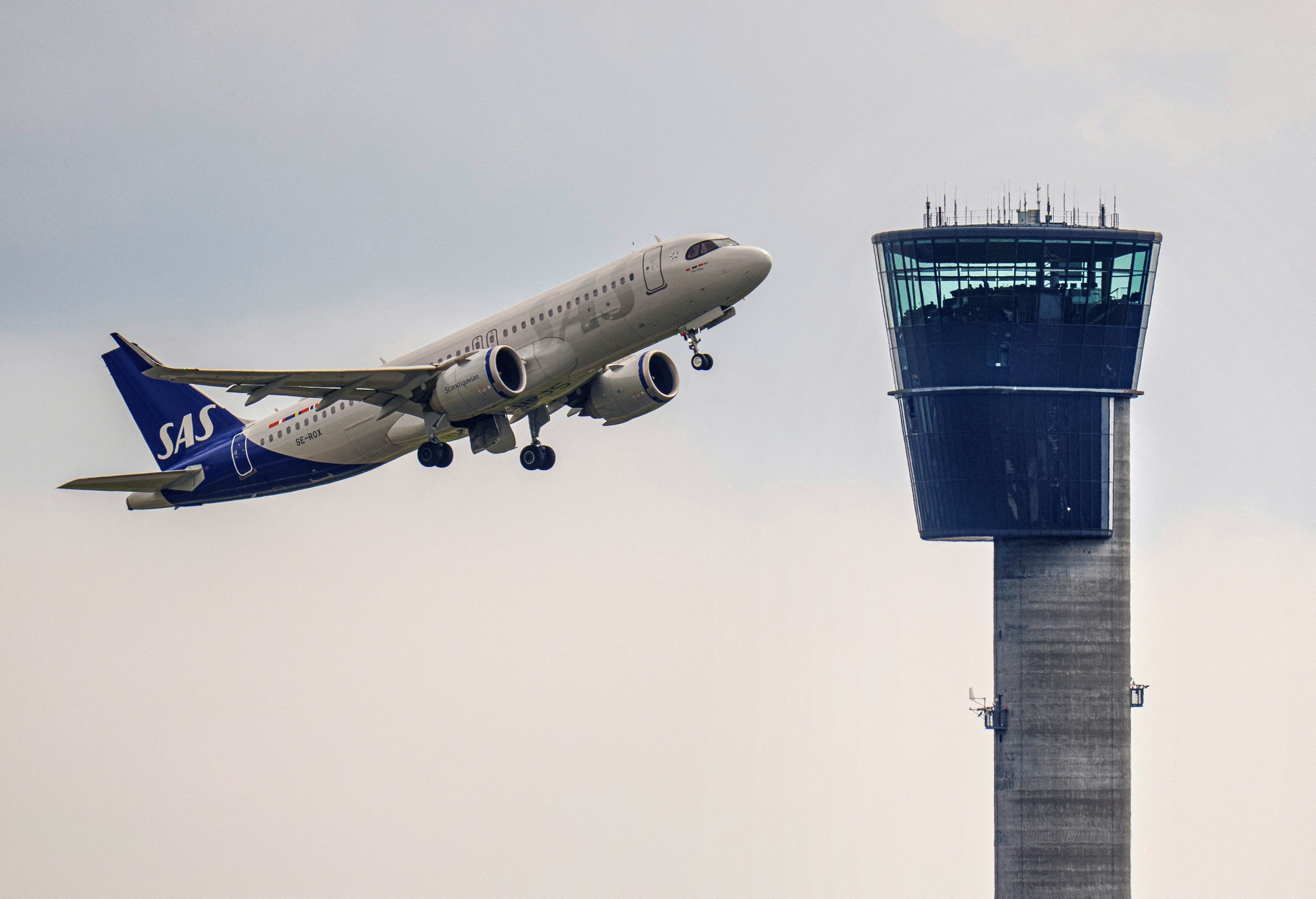 A photo taken on May 24, 2023 shows an aircraft of Scandinavian Airlines SAS taking off next to the Kastrup Tower at Copenhagen Airport, in Kastrup, Denmark, on May 24, 2023. The control tower is 70 meters tall. Aircraft that operate in Danish airspace receive help with landing and take-off from the controllers in the Naviair tower. (Photo by Liselotte Sabroe / Ritzau Scanpix / AFP) / Denmark OUT (Photo by LISELOTTE SABROE/Ritzau Scanpix/AFP via Getty Images)