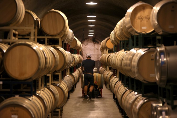ST HELENA, CALIFORNIA - SEPTEMBER 30: A worker pushes a wine barrell into a storage facility at Hunnicutt Wine Co. on September 30, 2021 in St Helena, California. One year after the 67,000 acre Glass Fire burned through the Napa Valley, the 2021 harvest is underway and nearing completion. (Photo by Justin Sullivan/Getty Images)