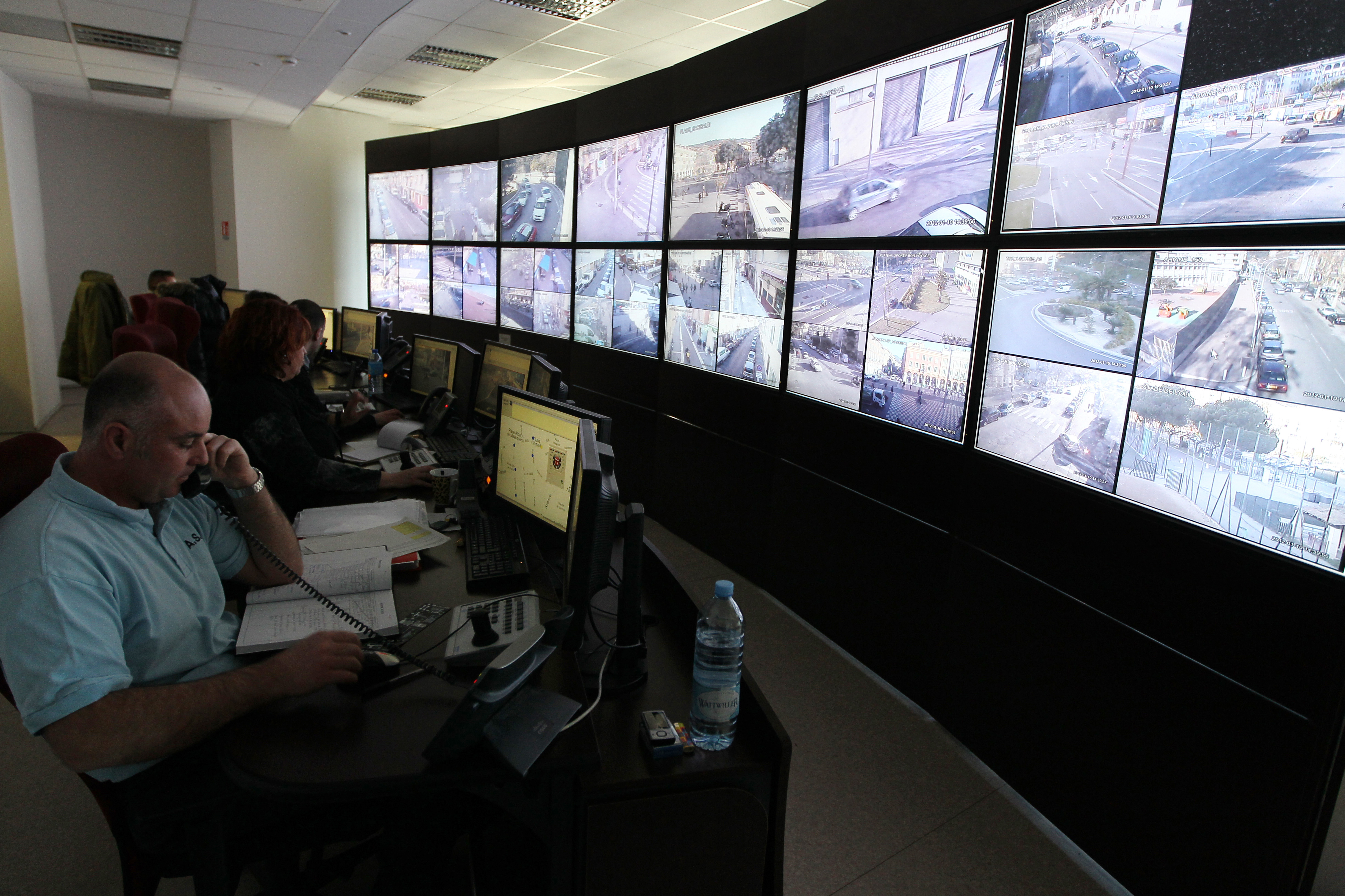 Policemen control on a giant screen videos taken from surveillance cameras in the streets of Nice, southeastern France, on January 10, 2012 at city police station. AFP PHOTO VALERY HACHE (Photo credit should read VALERY HACHE/AFP via Getty Images)