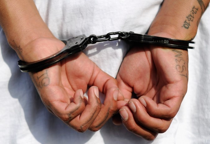 LOS ANGELES, CA - APRIL 29: Handcuffs are seen on the hands of a twenty-year old "Street Villains" gang member who was arrested by Los Angeles Police Department officers from the 77th Street division on April 29, 2012 in Los Angeles, California. The 77th Street division patrol the same neighborhood that truck driver Reginald Denny was nearly beaten to death by a group of black assailants at the intersection of Florence and Normandie Avenues. It’s been 20 years since the verdict was handed down in the Rodney King case that sparked infamous Los Angeles riots. (Photo by Kevork Djansezian/Getty Images)