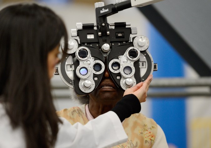 LOS ANGELES, CA - SEPTEMBER 27: An eye examination is performed as part of a free health care service at the Care Harbor clinic at the Los Angeles Sports Arena on September 27, 2012 in Los Angeles, California. Care Harbor is expected to give free medical, dental and vision care to 4,800 uninsured patients at the event, which runs from September 27-30. In Los Angeles County it is reported that 2.2 million people do not have health insurance, which includes an estimated 227,000 young and school-aged children. (Photo by Kevork Djansezian/Getty Images)
