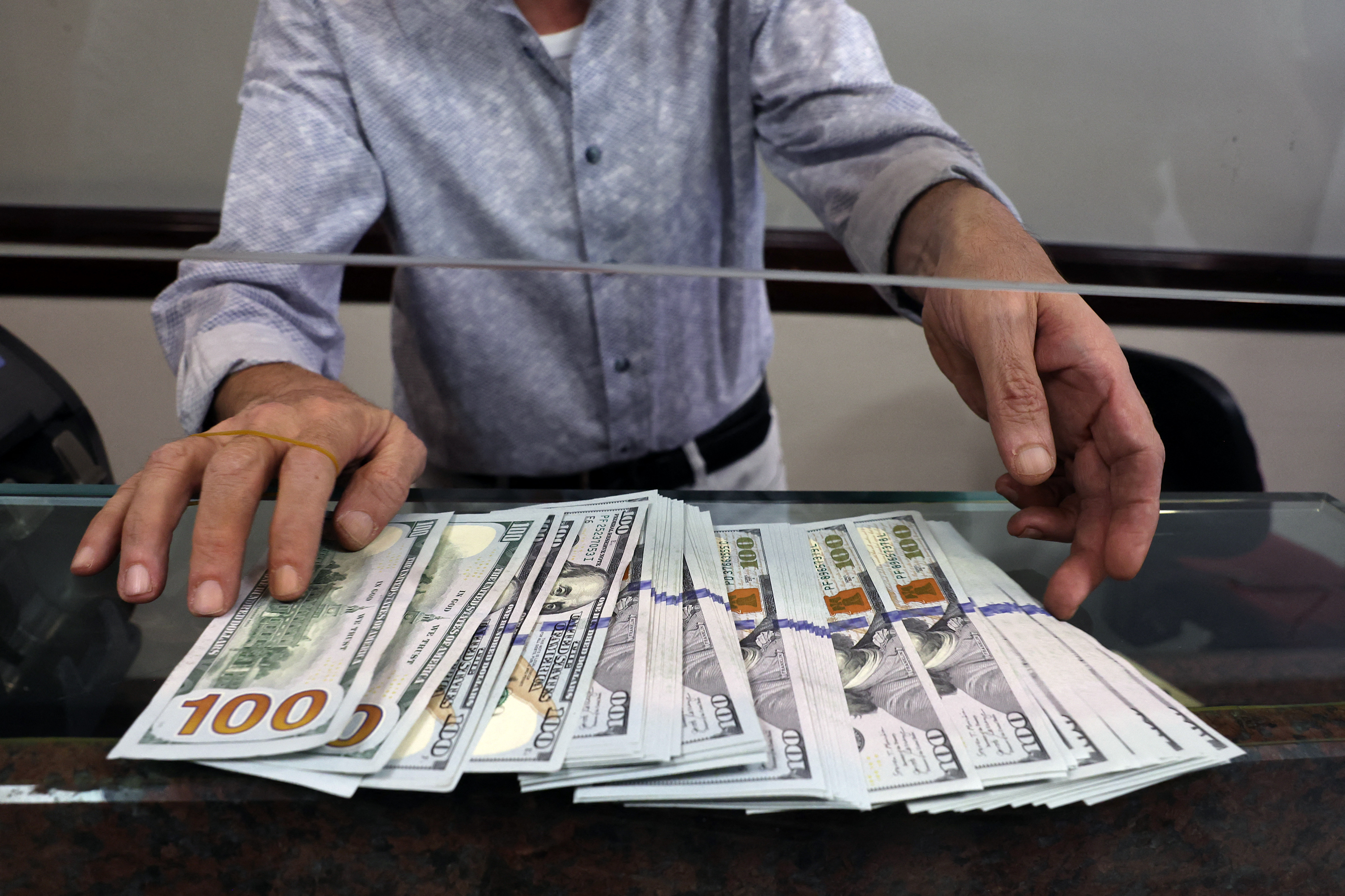 A teller shows US dollar bills at an exchange office in Ankara on July 20, 2023. Turkey's central bank hiked its main interest rate for the second month in a row, but analysts said the unwinding of President Recep Tayyip Erdogan's unconventional policy was too timid to tame inflation. After years of cuts that aimed to boost growth but fuelled inflation and caused the lira to tumble, the bank doubled its rate last month from 8.5 percent to 15 percent. The latest hike was smaller, at 2.5 percentage points, taking the rate to 17.5 percent. (Photo by Adem ALTAN / AFP) (Photo by ADEM ALTAN/AFP via Getty Images)