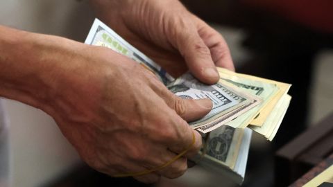 A teller counts US dollar bills at an exchange office in Ankara on July 20, 2023. Turkey's central bank hiked its main interest rate for the second month in a row, but analysts said the unwinding of President Recep Tayyip Erdogan's unconventional policy was too timid to tame inflation. After years of cuts that aimed to boost growth but fuelled inflation and caused the lira to tumble, the bank doubled its rate last month from 8.5 percent to 15 percent. The latest hike was smaller, at 2.5 percentage points, taking the rate to 17.5 percent. (Photo by Adem ALTAN / AFP) (Photo by ADEM ALTAN/AFP via Getty Images)