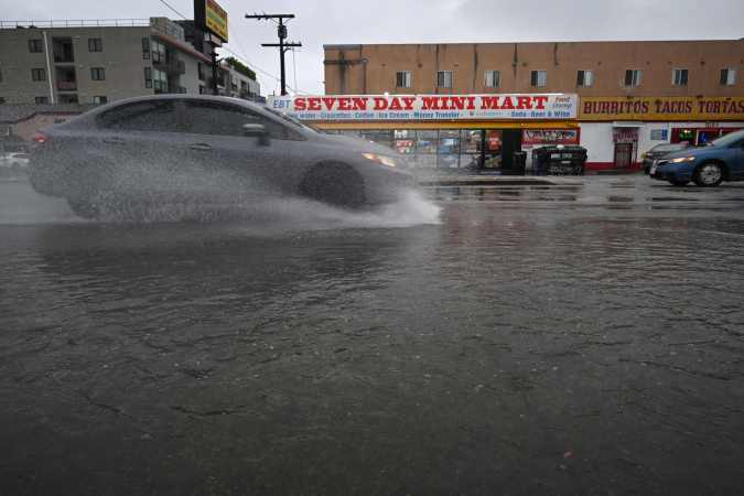 TOPSHOT - A car drives through a flooded street in North Hollywood, California on August 20, 2023. Heavy rains lashed California as Tropical Storm Hilary raced in from Mexico, bringing warnings of potentially life-threatening flooding in the typically arid southwestern United States. (Photo by Robyn Beck / AFP) (Photo by ROBYN BECK/AFP via Getty Images)