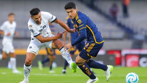 Nico Ibañez de Tigres disputa un balón con Eduardo Salvio de Pumas.