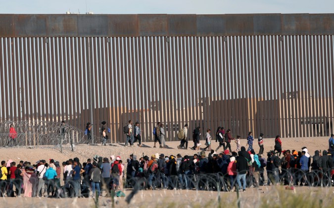 Migrantes que buscan asilo esperan para ser procesados por la Patrulla Fronteriza de Estados Unidos.