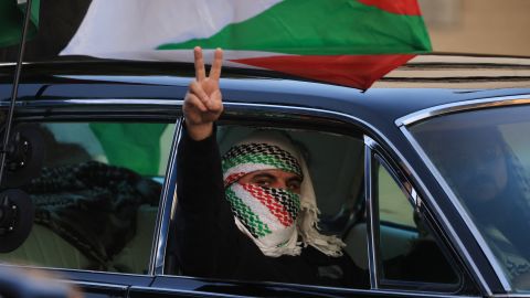 A passenger wearing a keffiyeh gestures a V sign as pro-Palestinian protesters rally during the "Black & Palestinian Solidarity for a Ceasefire this Xmas" by the Beverly Center shopping center in Los Angeles on December 23, 2023. More than 200 people were killed in 24 hours of Israeli strikes, Gaza officials said December 23, and Israel announced the death of five soldiers after the UN failed to call for a ceasefire. Eleven weeks into the Israel-Hamas war, Israeli forces pressed on with their offensive, a day after the UN Security Council adopted a resolution for more aid to flow into the besieged Gaza Strip. (Photo by DAVID SWANSON / AFP) (Photo by DAVID SWANSON/AFP via Getty Images)