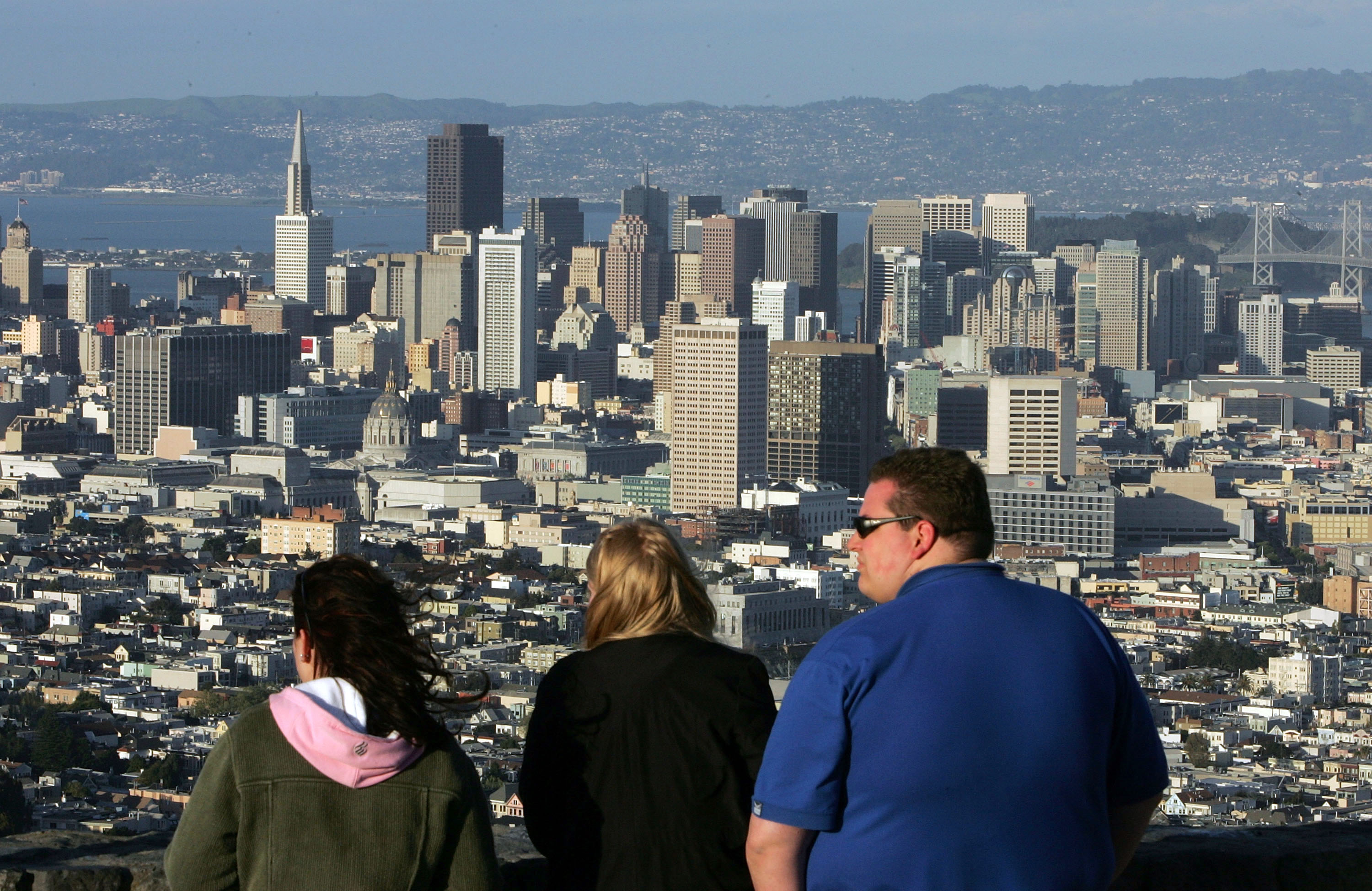 SAN FRANCISCO - MARCH 25: Tourists take in a view of downtown San Francisco from Twin Peaks March 25, 2005 in San Francisco, California. San Francisco's 49-Mile Scenic Drive was opened in 1939 as a guide for visitors to The City's 1939-1940 Golden Gate International Exposition. The route includes most of San Francisco's major sights as well as winding through many of the city's colorful neighborhoods; giving visitors a look into the diversity and beauty of the area. (Photo by Justin Sullivan/Getty Images)