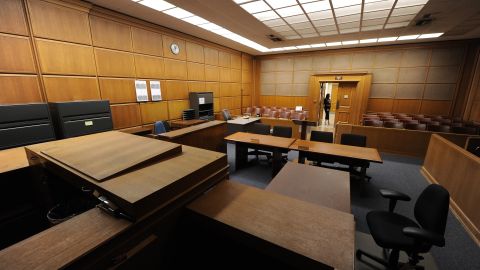 A woman stands in the doorway of a courtroom closed due to budget cuts and layoffs, at the Stanley Mosk Courthouse in downtown Los Angeles March 16, 2009. Beset by an unprecedented budget crisis, the LA Superior Court, the largest trial court system in the US, today laid of 329 employees and announced the closure of 17 courtrooms, with more of both expected in the future. AFP PHOTO / Robyn BECK (Photo credit should read ROBYN BECK/AFP via Getty Images)