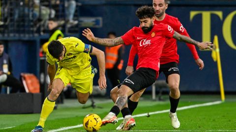 El delantero del Villarreal Gerard Moreno lucha por el balón con los jugadores del Mallorca.