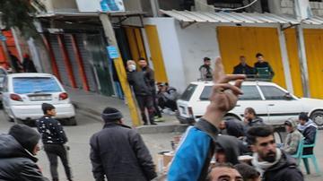 Los refugiados palestinos sostienen cuencos vacíos mientras intentan alcanzar los alimentos distribuidos por voluntarios en Rafah.