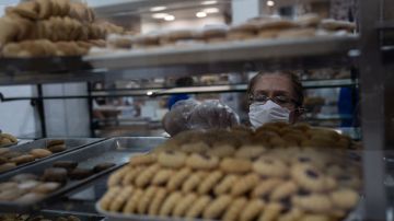 MEXICO CITY, MEXICO - MARCH 24: A bakery employee wearing a protective mask selects products during phase two of contingency measures to avoid the spread of COVID-19 on March 24, 2020 in Mexico City, Mexico. Beginning Monday, Mexico City ordered the closure of museums, bars, gyms, churches, theaters, with the exception of restaurants, in an attempt to contain COVID-19 pandemic. (Photo by Toya Sarno Jordan/Getty Images)
