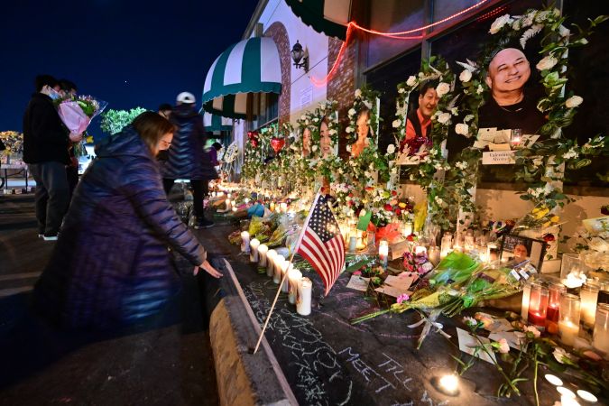 People pays their repect at a makeshift memorial for victims of a mass shooting in front of the Star Ballroom Dance Studio in Monterey Park, California on January 26, 2023. (Photo by Frederic J. BROWN / AFP) (Photo by FREDERIC J. BROWN/AFP via Getty Images)