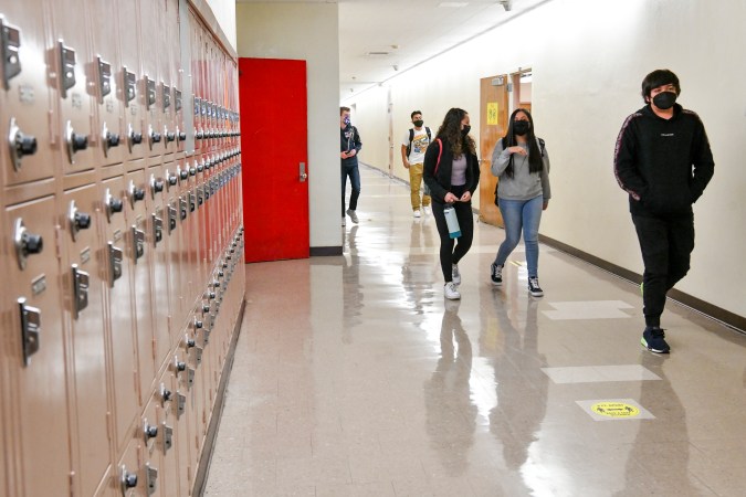 LOS ANGELES, CALIFORNIA - APRIL 27: Returning students walk the hallway at Hollywood High School on April 27, 2021 in Los Angeles, California. Los Angeles Unified School District middle and high schools have reopened this week for in-person instruction. COVID-19 protocols in place include testing for all students and staff, vaccinations for all staff, and a completed daily health check for anyone arriving on campus (Photo by Rodin Eckenroth/Getty Images)