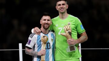 LUSAIL CITY, QATAR - DECEMBER 18: Adidas Golden Ball winner Lionel Messi (L) and adidas Golden Glove winner Emiliano Martinez (R) of Argentina pose at the award ceremony following the FIFA World Cup Qatar 2022 Final match between Argentina and France at Lusail Stadium on December 18, 2022 in Lusail City, Qatar. (Photo by Julian Finney/Getty Images)