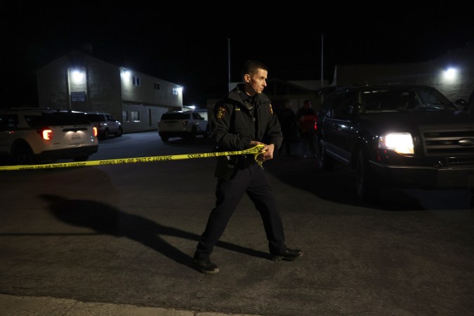 HALF MOON BAY, CALIFORNIA - JANUARY 23: A San Mateo County sheriff deputy pulls police tape across the entrance to a family reunification center following a mass shooting on January 23, 2023 in Half Moon Bay, California. Seven people were killed at two separate farm locations that were only a few miles apart in Half Moon Bay on Monday afternoon. The suspect, Chunli Zhao, was taken into custody a few hours later without incident. (Photo by Justin Sullivan/Getty Images)