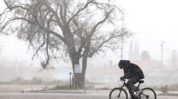 PALMDALE, CALIFORNIA - MARCH 01: A person cycles through snow in Los Angeles County during another winter storm in Southern California on March 01, 2023 in Palmdale, California. The final in a series of winter storms in the Los Angeles region brought snow levels to as low as 1,000 feet in some places while further boosting the snowpack. California’s snowpack level stands at 189 percent of the average for March 1, according to the California Department of Water Resources. California Governor Gavin Newsom has declared a state of emergency due to winter storms for 13 counties including Los Angeles County. (Photo by Mario Tama/Getty Images)