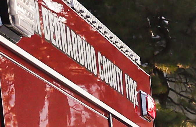 CRESTLINE, CALIFORNIA - MARCH 03: A crew of inmate firefighters (L) walk back to their vehicle after shoveling and clearing snow, while people carry bags of food (R), after a series of winter storms in the San Bernardino Mountains in Southern California on March 3, 2023 in Crestline, California. Some residents have been stranded in Crestline more than a week due to the snowfall while the local grocery store was severely damaged when its roof collapsed under the weight of the snow. California Governor Gavin Newsom has declared a state of emergency due to winter storms for 13 counties including San Bernardino County and the California National Guard is assisting relief efforts in the mountains. (Photo by Mario Tama/Getty Images)