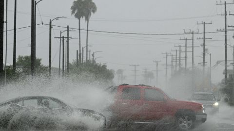 Vehicles splash up water during heavy rains from Tropical Storm Hilary, in south Los Angeles, California, on August 20, 2023. Hurricane Hilary weakened to a tropical storm on August 20, 2023, as it barreled up Mexico's Pacific coast, but was still likely to bring life-threatening flooding to the typically arid southwestern United States, forecasters said. Authorities reported at least one fatality in northwestern Mexico, where Hilary lashed the Baja California Peninsula with heavy rain and strong winds. (Photo by Robyn BECK / AFP) (Photo by ROBYN BECK/AFP via Getty Images)