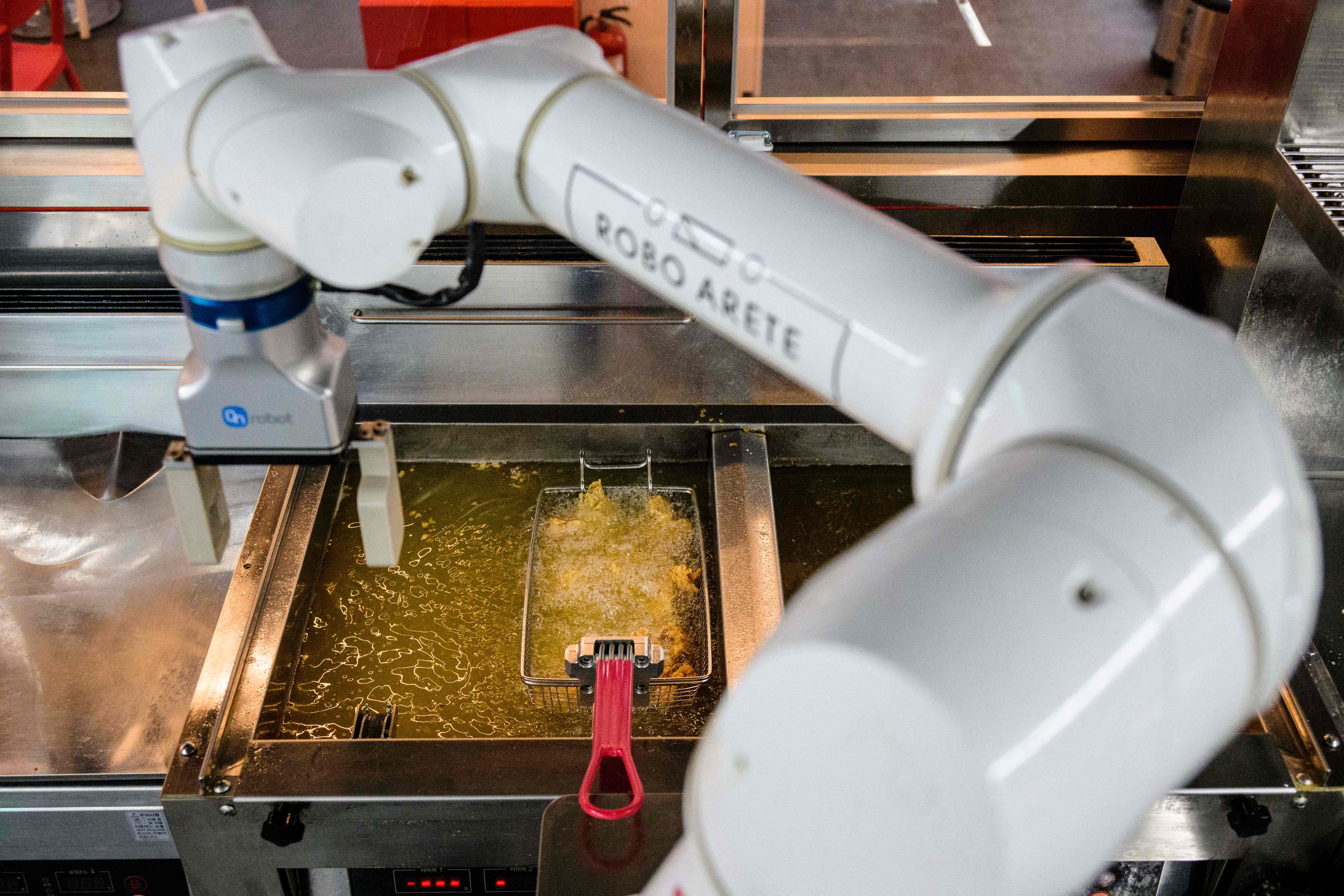 In this photo taken on June 13, 2023, a robot is used to fry chicken at Robert's Chicken restaurant in Seoul.  In fried-chicken-obsessed South Korea, restaurants serving the country's favorite fast-food dish are on every street corner.  But Kang Ji-young's setup is a little different: a robot cooks chicken.  (Photo by Anthony Wallace/AFP) / To go with the AFP story scoria-food-drink-culture-technology, focus by Claire Lee (Photo by Anthony Wallace/AFP via Getty Images)