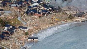 TOPSHOT - This aerial photo provided by Jiji Press shows smoke rising from a house fire (top R) along with other damage along the coast in the town of Noto, Ishikawa prefecture on January 2, 2024, a day after a major 7.5 magnitude earthquake struck the Noto region in Ishikawa prefecture. Japanese rescuers battled against the clock and powerful aftershocks on January 2 to find survivors of a major earthquake that struck on New Year's Day, killing at least 30 people and causing widespread destruction. (Photo by JIJI PRESS / AFP) / Japan OUT (Photo by STR/JIJI PRESS/AFP via Getty Images)