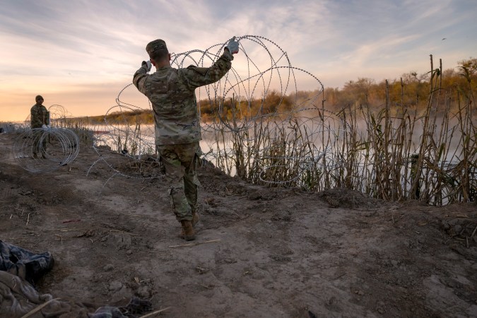 Soldados de la Guardia Nacional de Texas instalan más alambre de púas a lo largo del Río Grande en Eagle Pass.