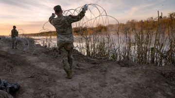 Soldados de la Guardia Nacional de Texas instalan más alambre de púas a lo largo del Río Grande en Eagle Pass.