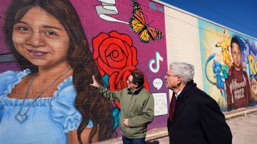 El artista Abel Ortiz (i) ofrece al fiscal general Merrick Garland (d), un recorrido por los murales que honran a las víctimas del tiroteo en Uvalde, Texas.