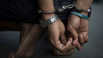 TOPSHOT - An alleged drug dealer is captured by policemen after a drug buy-bust operation on a slum area in Manila on September 28, 2017. Nearly half of Filipinos believe police are killing innocent people in waging President Rodrigo Duterte's anti-drugs war, according to survey results released Wednesday. / AFP PHOTO / NOEL CELIS (Photo credit should read NOEL CELIS/AFP via Getty Images)