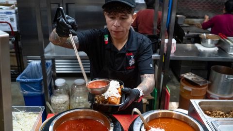 Alejandro Albarrán prepara una torta ahogada en el puesto de Chiva Torta en el Mercado González en Costa Mesa.