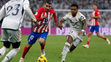 El delantero del Real Madrid, Rodrygo, pelea una posesión con el volante del Atlético de Madrid Ángel Correa durante el derbi madrileño en el Santiago Bernabéu.