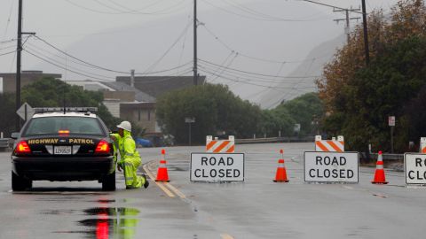 A road worker stops to talk to a Highway Patrol officer at a road closure, where there was a rock slide on the Pacific Coast Highway at the Ventura County line on Monday, Dec. 20,2010. A storm pounding California with record rain and heavy snow spawned minor flooding, mudslides, small evacuations and road closures Monday, but forecasters warned that the bad weather's worst impact may be yet to come. (AP Photo/Nick Ut)