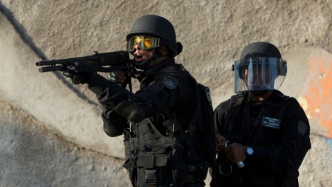 A riot policeman aims his weapon at protesters during a demonstration in Belo Horizonte, Brazil, Wednesday, June 26, 2013. Brazilian anti-government protesters in part angered by the billions spent in World Cup preparations and police clashed Wednesday near the stadium hosting a Confederations Cup football match, with tens of thousands of demonstrators trying to march on the site confronting police firing tear gas and rubber bullets. (AP Photo/Victor R. Caivano)