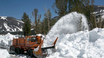 In this photo taken Tuesday, June 6, 2017, a Caltrans rotary blower clears snow from Highway 120 near near Yosemite National Park, Calif. This year's heavy snowfall has crews working to clear Highway 120 as summer approaches, the only road through Yosemite that connects the Central Valley on the west side with the Owens Valley on the east side of the Sierra Nevada. (AP Photo/Rich Pedroncelli)
