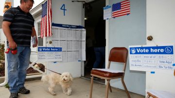 FILE - In this Tuesday, June 5, 2018 file photo, Peter Brubaker and his dog Albert arrive to cast his vote at a polling station inside the First Christian Church in Torrance, Calif. Early returns show turnout in California's Tuesday primary election was low. Counties are still receiving and counting ballots, which could ultimately make up a significant percentage of the total. (AP Photo/Damian Dovarganes, File)