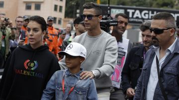Cristiano Ronaldo, center, with his partner Georgina Rodriguez, left, and his son Cristiano Ronaldo Jr walk at the pit line ahead of the second practice session at the Monaco racetrack, in Monaco, Thursday, May 23, 2019. The Formula one race will be held on Sunday. (AP Photo/Luca Bruno)