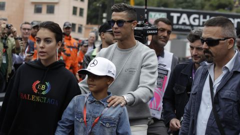 Cristiano Ronaldo, center, with his partner Georgina Rodriguez, left, and his son Cristiano Ronaldo Jr walk at the pit line ahead of the second practice session at the Monaco racetrack, in Monaco, Thursday, May 23, 2019. The Formula one race will be held on Sunday. (AP Photo/Luca Bruno)