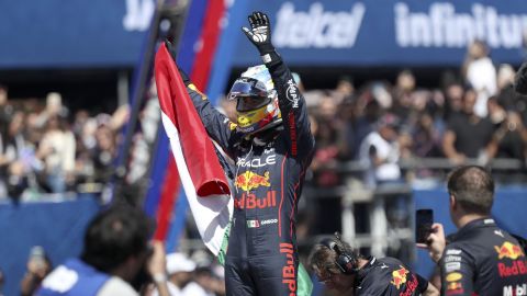 Mexican Formula One Red Bull driver Sergio "Checo" Perez waves at fans while holding a Mexican national flag after an exhibition race through the streets of Guadalajara, Mexico, Tuesday, Oct. 25, 2022. Perez will compete in the upcoming Mexico Grand Prix in Mexico City. (AP Photo)