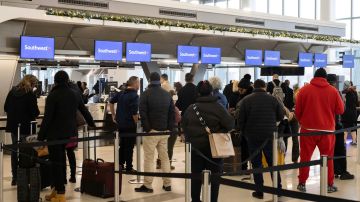 Pasajeros esperan para registrarse para sus vuelos en un mostrador de la aerolínea Southwest Airlines en el Aeropuerto de LaGuardia, el 27 de diciembre de 2022, en Nueva York