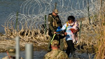 Inmigrantes son detenidos en la frontera entre Texas y México, en Eagle Pass, Texas.