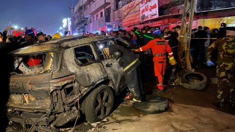 Agentes del orden rodean un vehículo que fue el objetivo de un ataque con aviones no tripulados de EE.UU. en Bagdad, Irak.