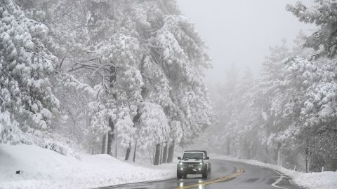 A car drives on the Sunrise Highway through the Cleveland National Forest Wednesday, Feb. 7, 2024, in eastern San Diego County, Calif. According to the National Weather Service snow level is down to 4500 feet in the San Diego County mountains. (AP Photo/Denis Poroy)