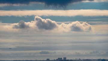 A plane descends into Los Angeles International Airport as low clouds gather over the Pacific ahead of forecasted rain in Los Angeles, Sunday, Feb. 18, 2024. (AP Photo/Damian Dovarganes)