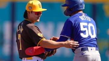 San Diego Padres shortstop Ha-Seong Kim reaches out to Los Angeles Dodgers' Mookie Betts (50) after they collided at second base during the first inning of a spring training baseball game Thursday, Feb. 22, 2024, in Peoria, Ariz. (AP Photo/Lindsey Wasson)