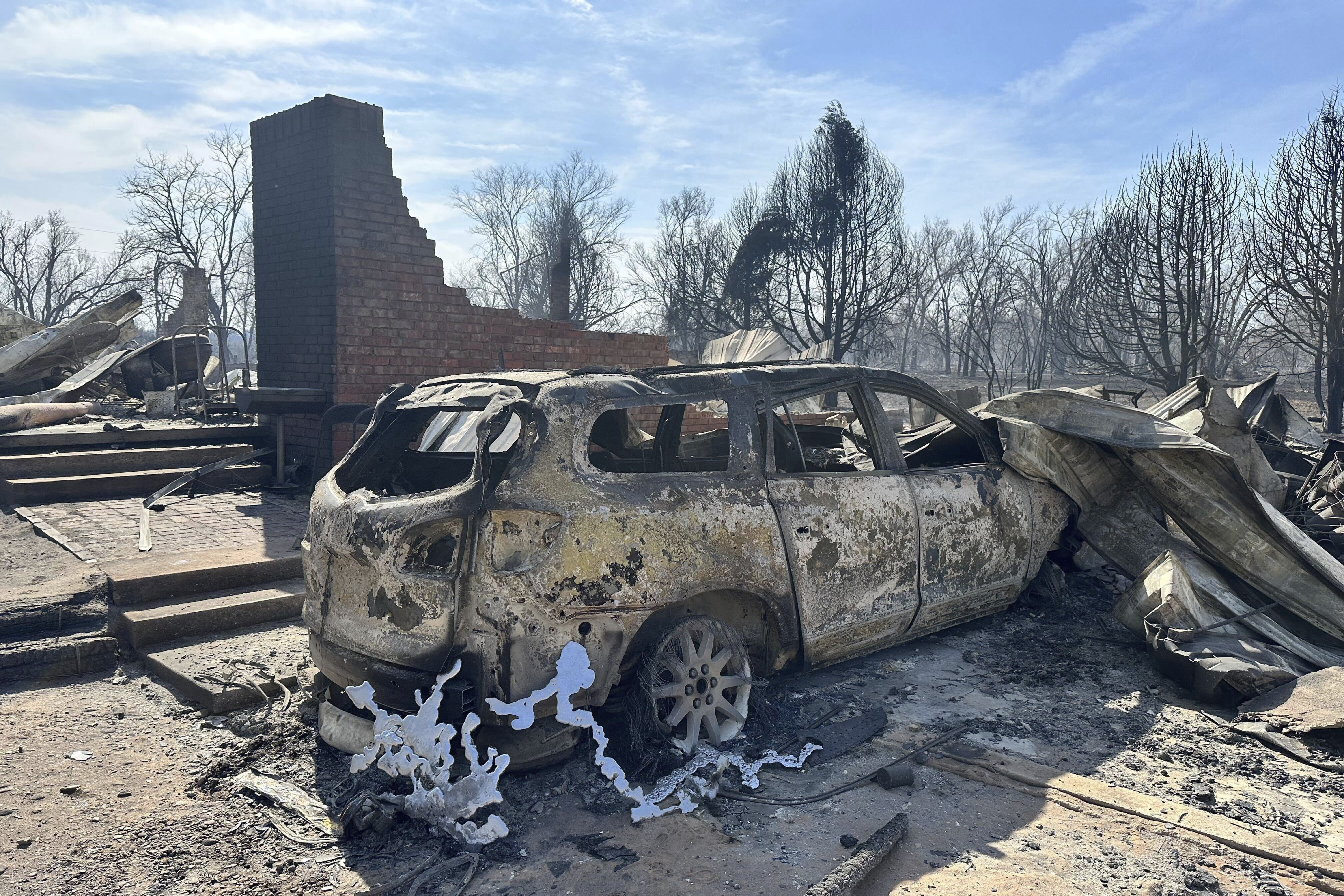 Un automóvil quemado cerca de los restos de una casa destruida en las afueras de Canadian, Texas, el 28 de febrero de 2024.