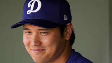 FILE - Los Angeles Dodgers designated hitter Shohei Ohtani smiles in the dugout before a spring training baseball game against the Texas Rangers, on Feb. 28, 2024, in Surprise, Ariz. Baseball star Ohtani announced on in Instagram account that he has been married. (AP Photo/Lindsey Wasson, File)