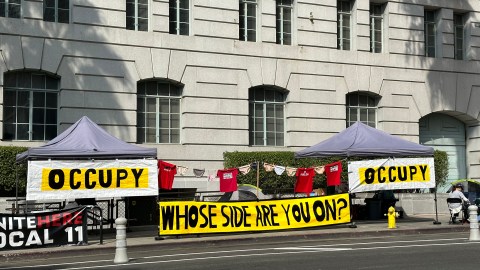 Trabajadores en huelga del Grand Hotel de Los Ángeles ocupan las banquetas del Ayuntamiento de Los Ángeles. (Araceli Martínez/La Opinión)