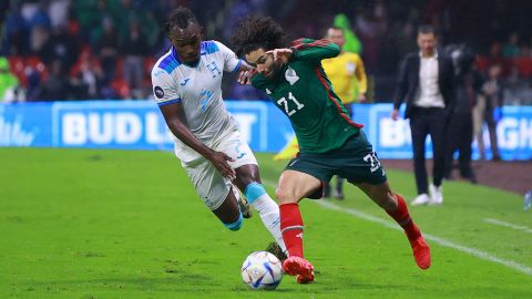 Alberth Elis disputa un balón con César huerta durante un partido entre Honduras y México.