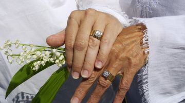 Suzanne Nightingale, 49, left, and Kathleen Clementson, 62, of Cape Coral, Fla., display their rings for a photographer during their wedding ceremony on Saint's Landing Beach in Brewster, Mass. Thursday, May 20, 2004 during the first week of state-sanctioned gay marriage in America. The new round of nuptials for gay couples came Thursday as Mass. Gov. Mitt Romney took the first steps toward blocking city and town clerks from issuing marriage licenses to out-of-state gay couples, which the Republican governor says is prohibited by state law. (AP Photo/Elise Amendola)